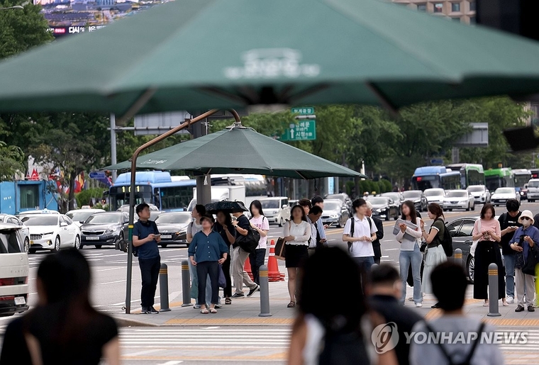 더운 날씨가 이어지는 23일 서울 광화문광장에서 시민들이 그늘막 아래서 보행 신호를 기다리고 있다.. 사진=연합뉴스