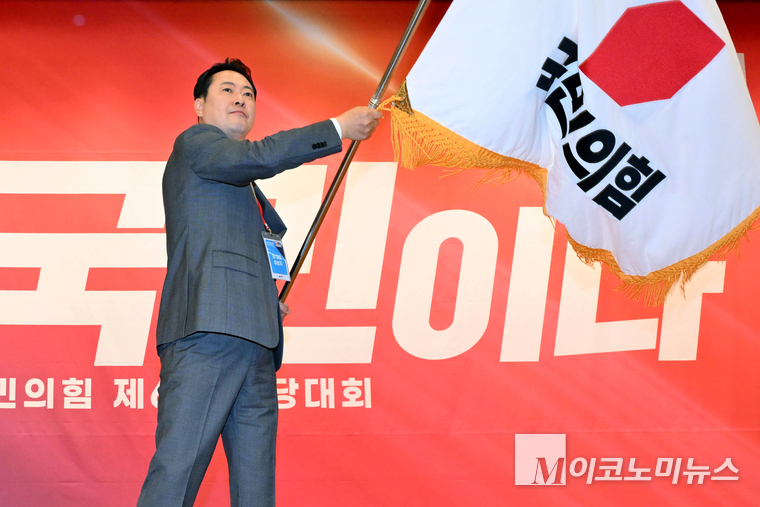 장동혁 신임 대표가 26일 국회 도서관에서 열린 제6차 전당대회 당대표 결선투표에서 당기를 흔들고 있다. 사진=공동취재단