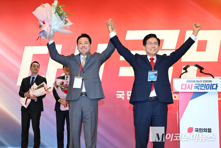 장동혁 신임 대표가 26일 국회 도서관에서 열린 제6차 전당대회 당대표 결선투표 꽃다발을 받고 김문수 후보와 기념촬영하고 있다. 사진=공동취재단