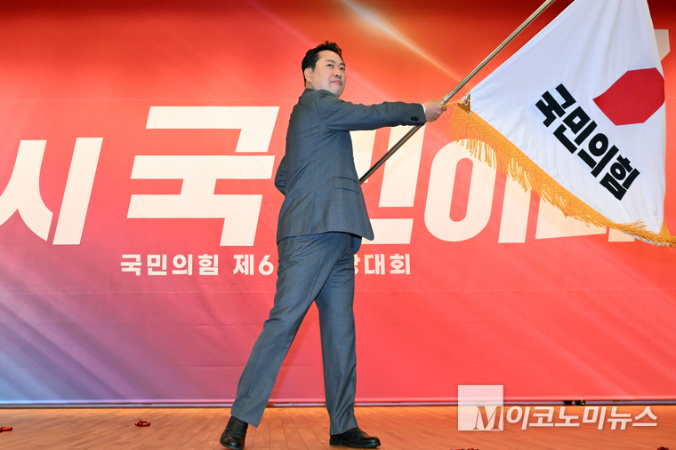 장동혁 신임 대표가 26일 국회 도서관에서 열린 제6차 전당대회 당대표 결선투표에서 당기를 흔들고 있다. 사진=공동취재단