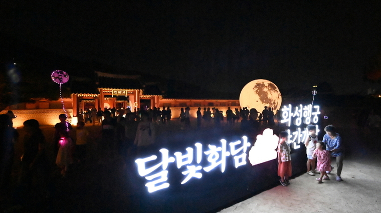 화성행궁 야간개장 ‘달빛화담’ 조명 구조물을 시민들이 관람하는 모습 <수원시 제공>