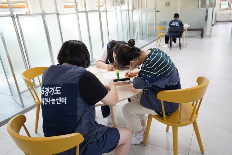 청소년들이 봉사활동으로 입양 홍보 카드를 작성하고 있는 모습. / 사진 제공 : 경기도 